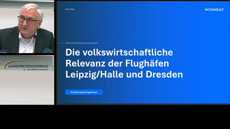 Auf dem Bild ist Sachsen-Anhalts Finanzminister Michael Richter zu sehen sowie eine Powerpoint-Seite mit Informationen zur volkswirtschaftlichen Relevanz der Flughäfen Leipzig-Halle und Dresden..